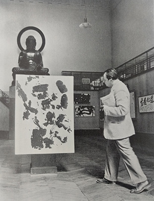 L. Alcopley contemplating work by Eguchi Sōgen at the exhibition of modern Japanese calligraphy at Museum Cernuschi in 1953. Photograph from Bokubi no. 58 (September 1956), p. 9